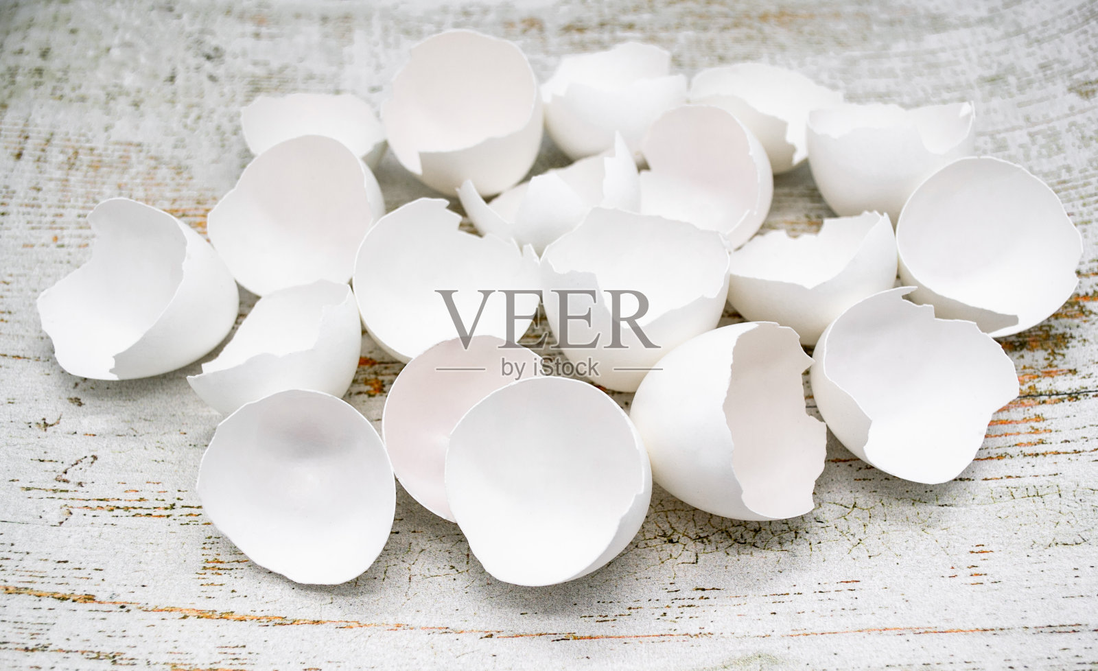 在一个古老的木头背景上的许多破碎的白色蛋壳的特写照片摄影图片