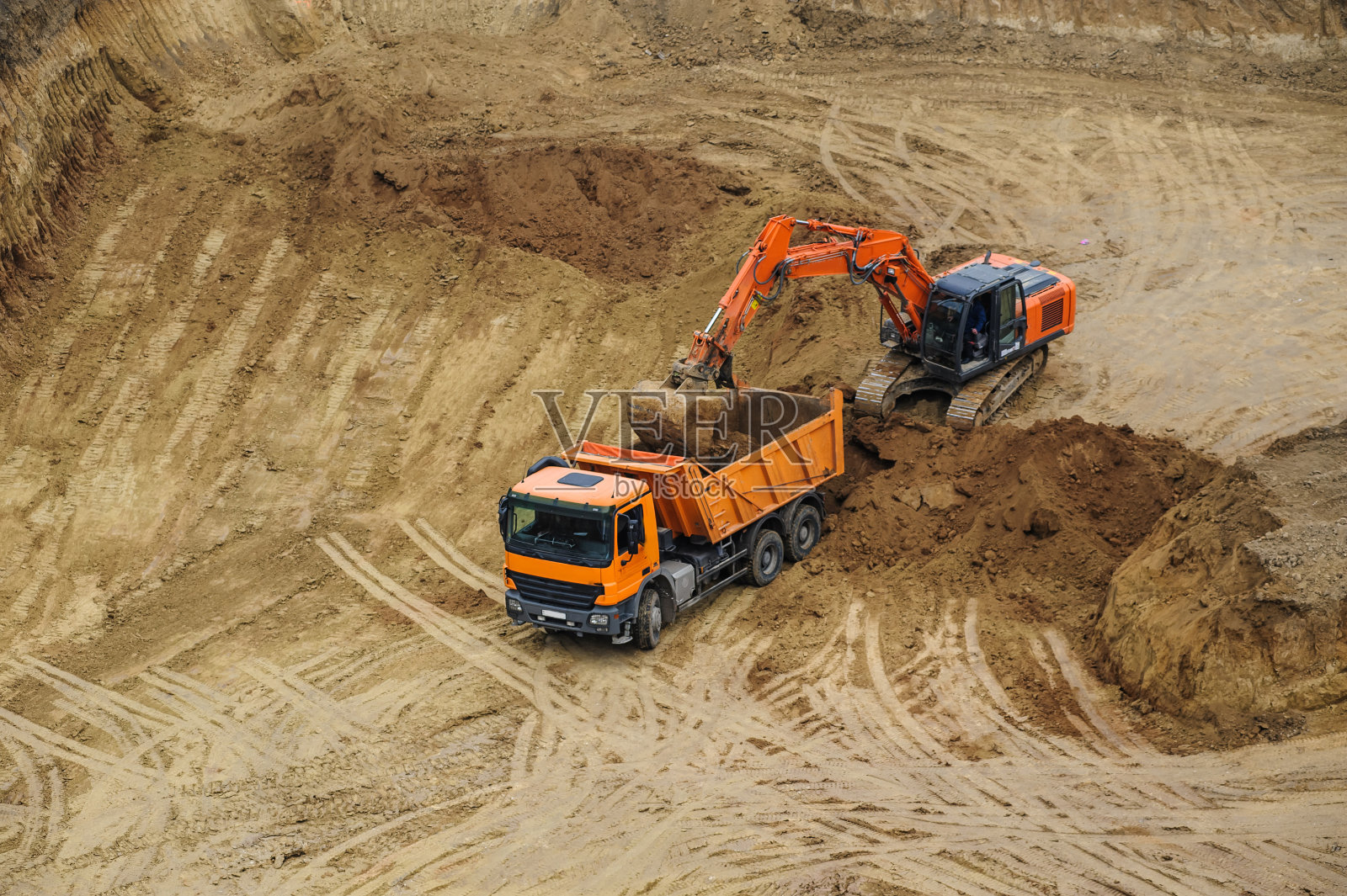 挖土机把土搬到自卸卡车上照片摄影图片