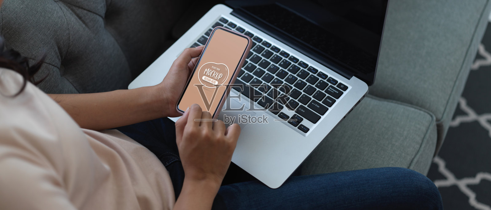 女性在沙发上放松的时候使用模拟智能手机和笔记本电脑照片摄影图片