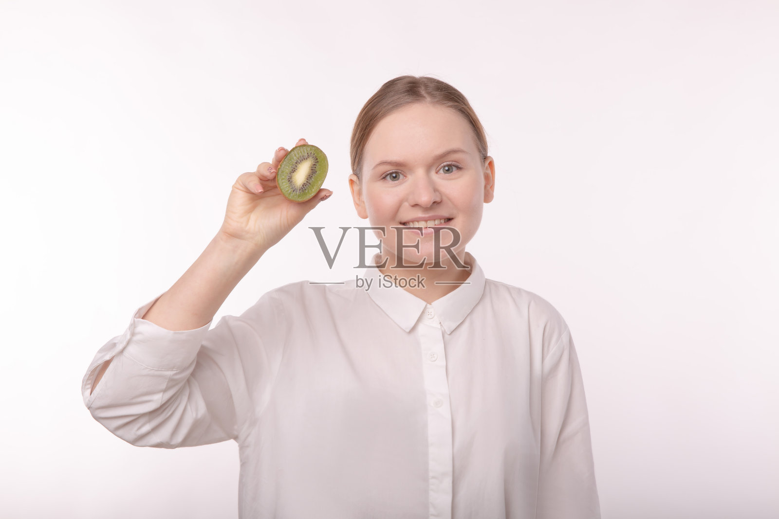 一个没化妆的女孩拿着几维鸟看镜头。照片摄影图片