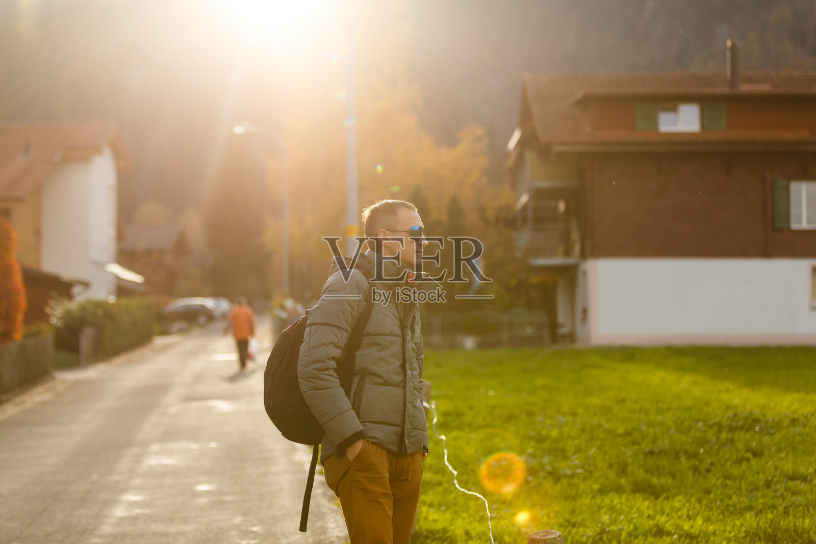 年轻英俊的搭车人站在高速公路上。冒险和旅游的概念。照片摄影图片
