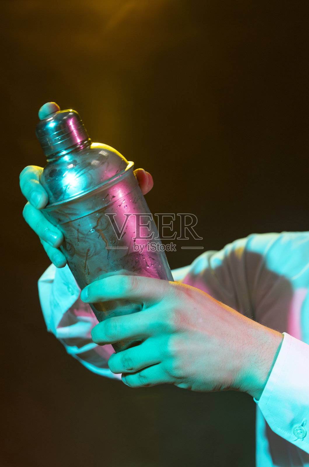 酒保准备酒精饮料与鸡尾酒调酒器在酒吧与一些酒杯利口酒。照片摄影图片