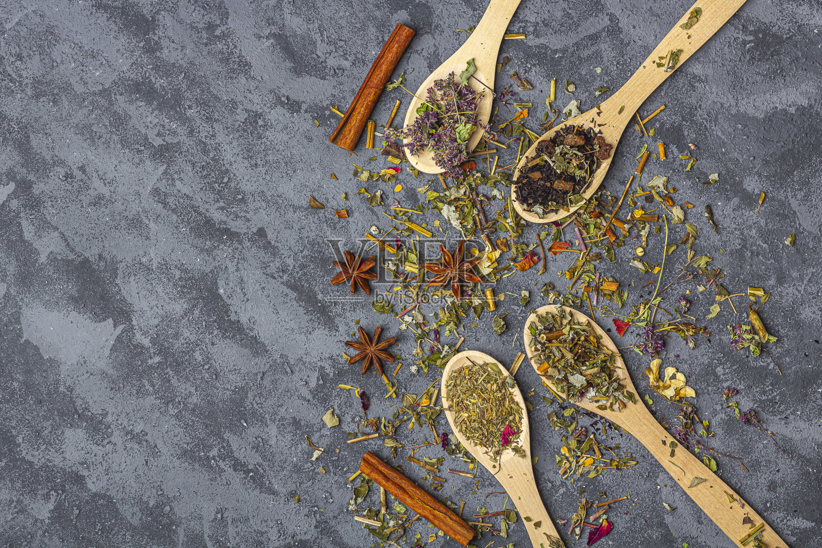 各种不同的干茶在木汤匙与茴香和肉桂田园风格。有机草药,绿茶和红茶与干花瓣茶道。关闭,为文本复制空间照片摄影图片