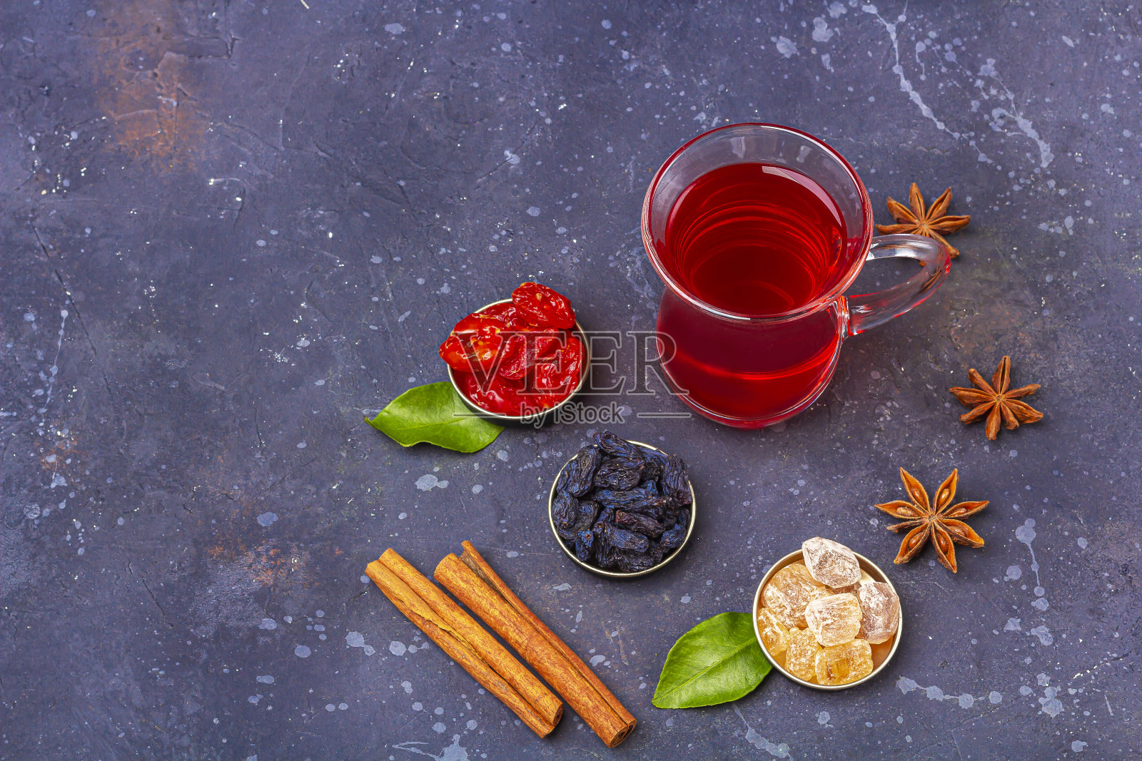 土耳其茶杯(armudu)中红茶(roibos,木槿,karkade)与山茱萸,葡萄干,糖在深色的背景上。草药,维生素,治疗感冒和流感的排毒茶。文本复制空间照片摄影图片