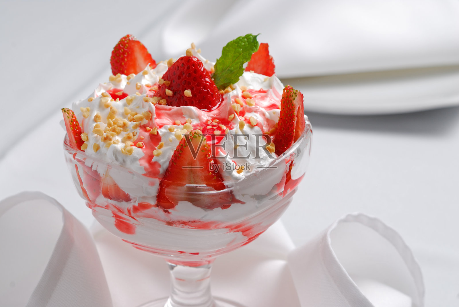 草莓甜点,鲜奶油和碎坚果。照片摄影图片