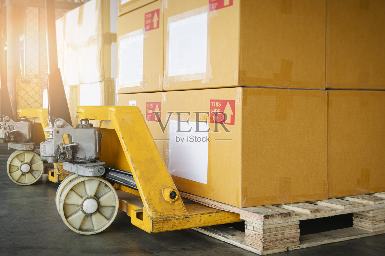 在仓库仓库用托盘装纸箱的手动托盘千斤顶。装运,货物运费,交货。物流和运输。ภาษาของคำสำคัญ:英语照片摄影图片