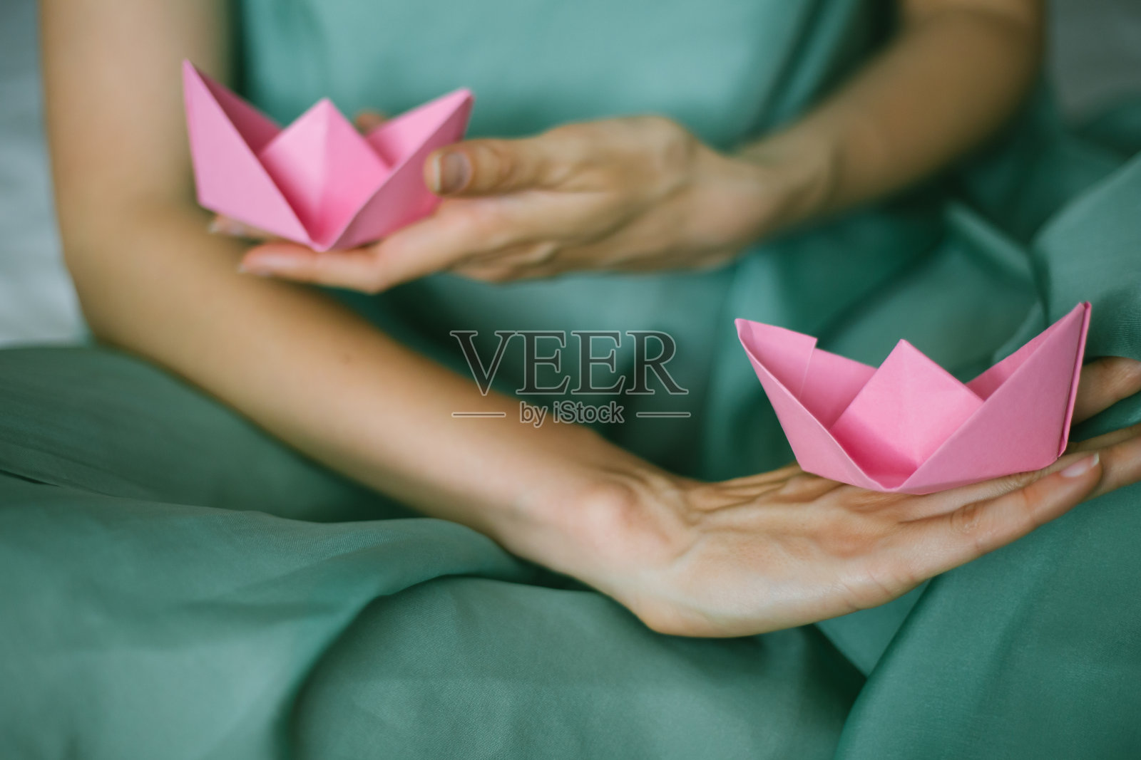 两艘粉红色的折纸船在波浪的手照片摄影图片