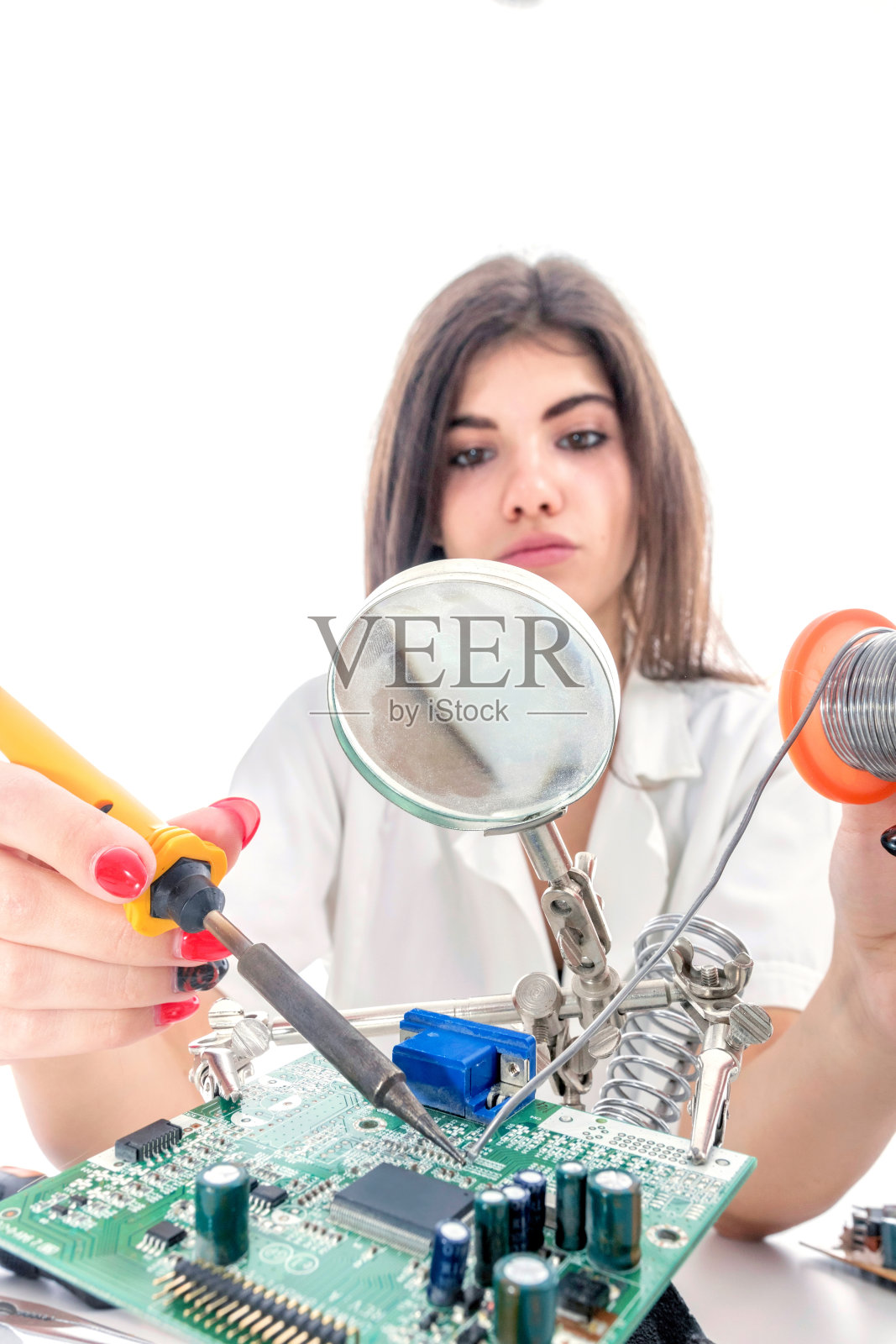 女电子技术员使用电烙铁修理电子设备照片摄影图片