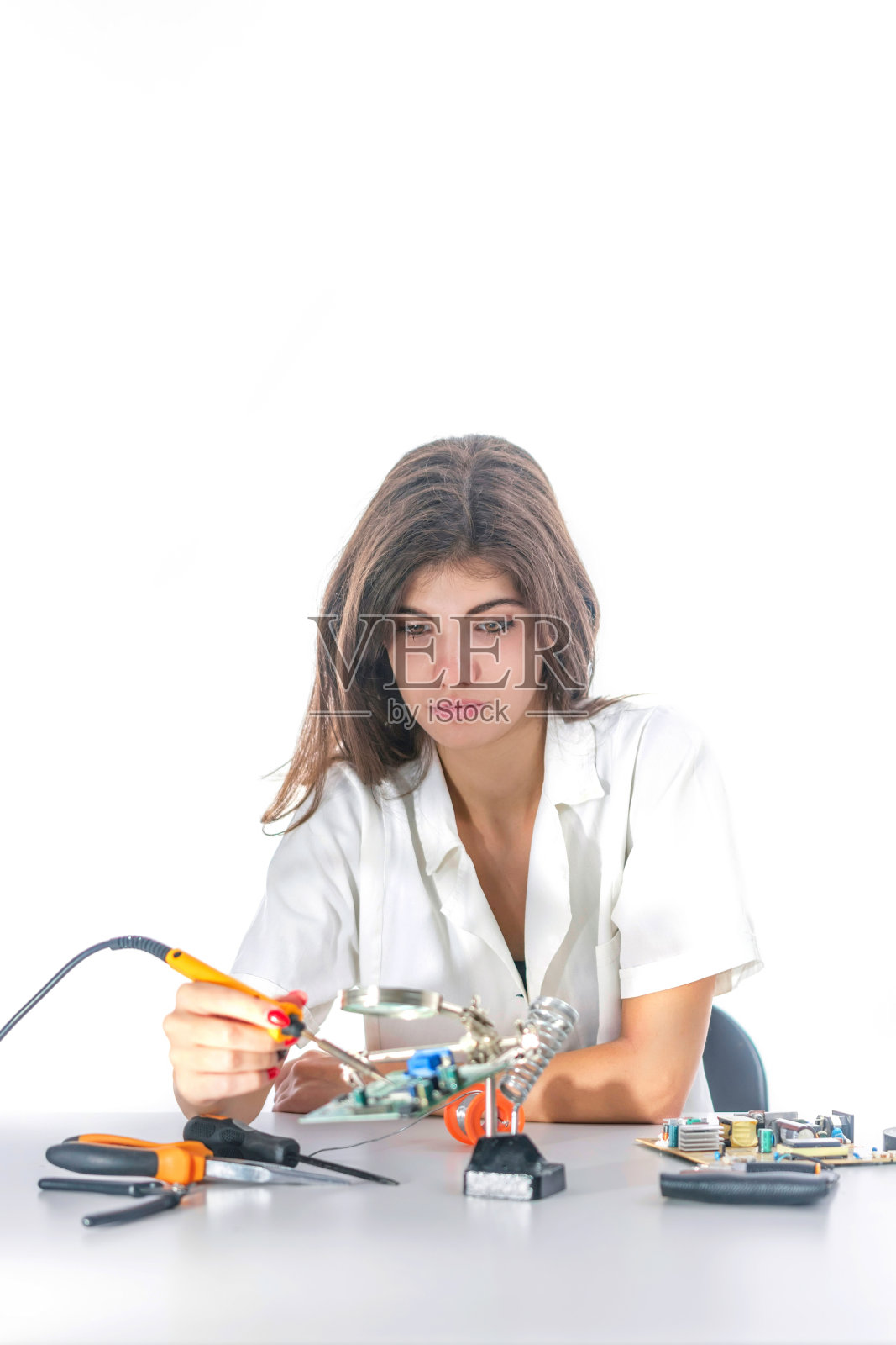 女电子技术员使用电烙铁修理电子设备照片摄影图片