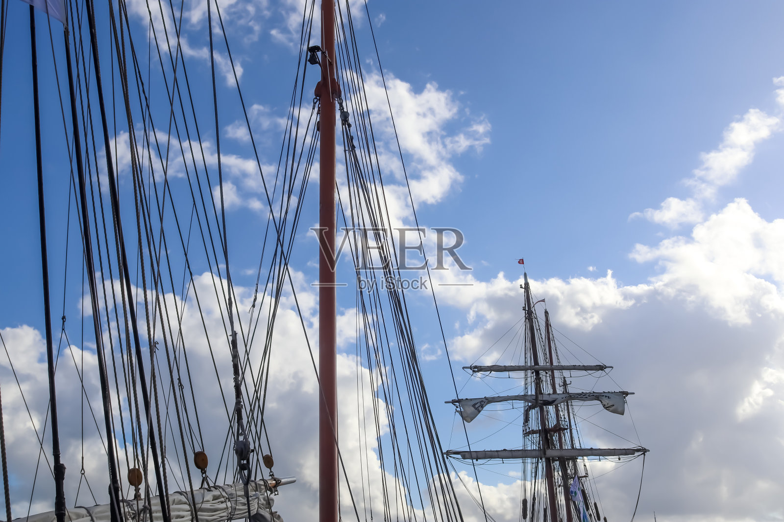在一些帆船上,帆桅以帆索的细节衬托着蓝天。照片摄影图片