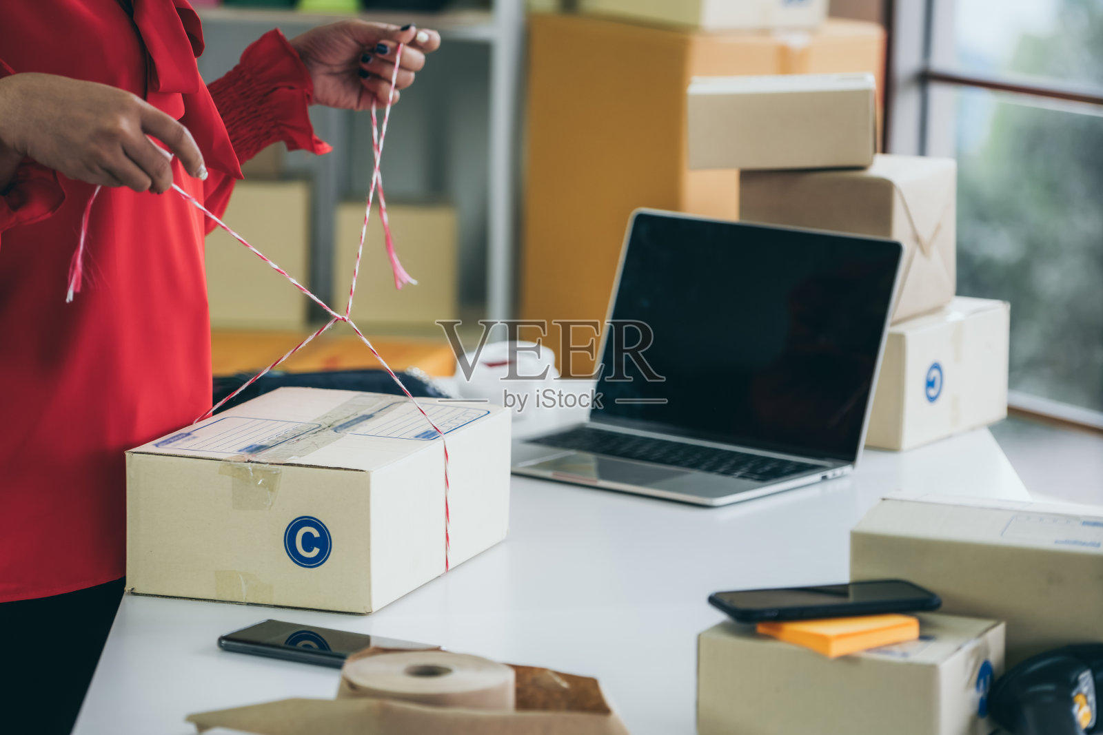 网上卖家工作在家办公和包装运输交付盒给客户。照片摄影图片