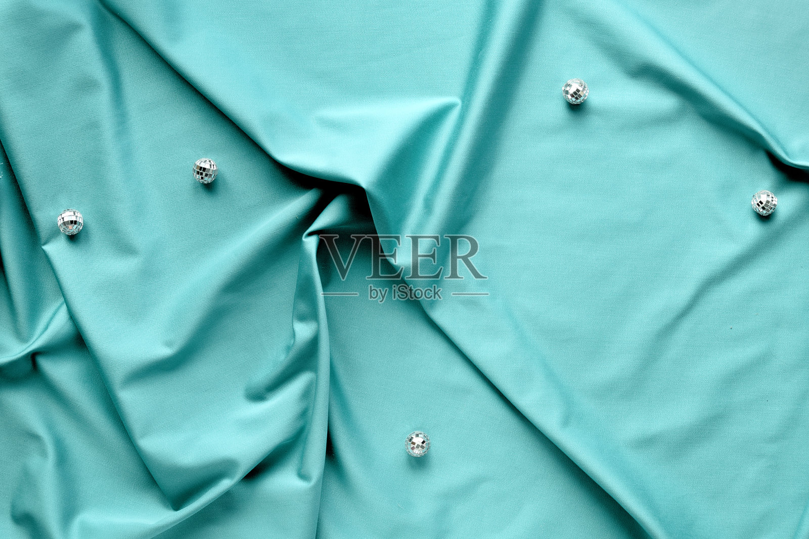 AI水蓝色——2021年的流行色。时尚俯视图,薄荷蓝色纺织品上的迪斯科球照片摄影图片