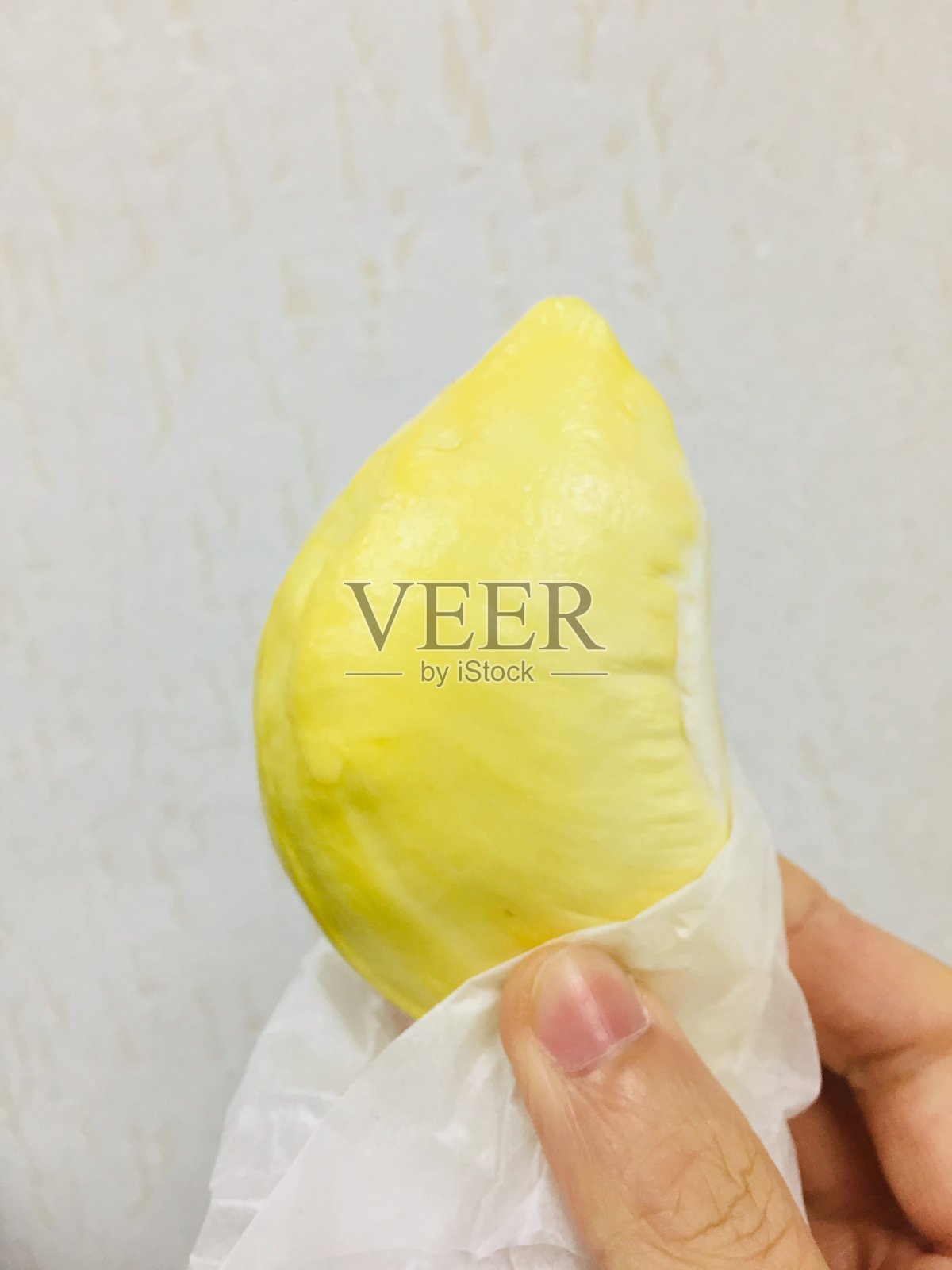 手里拿着一片榴莲。照片摄影图片