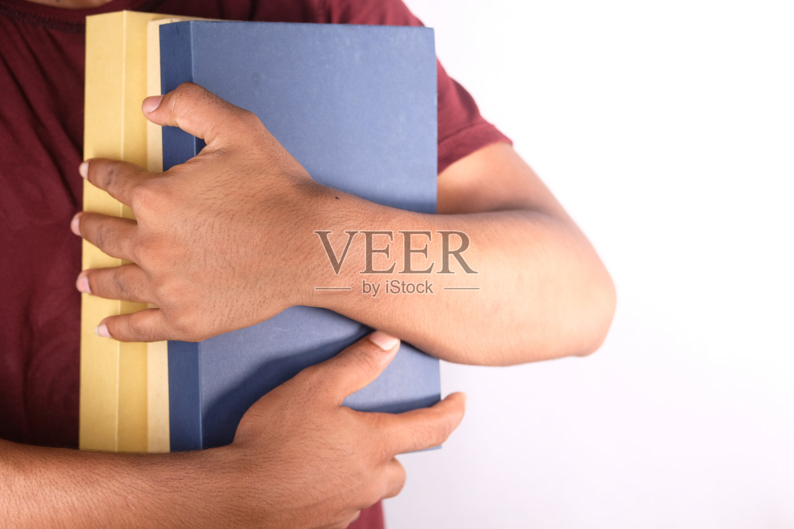 手握堆书的颜色背景照片摄影图片