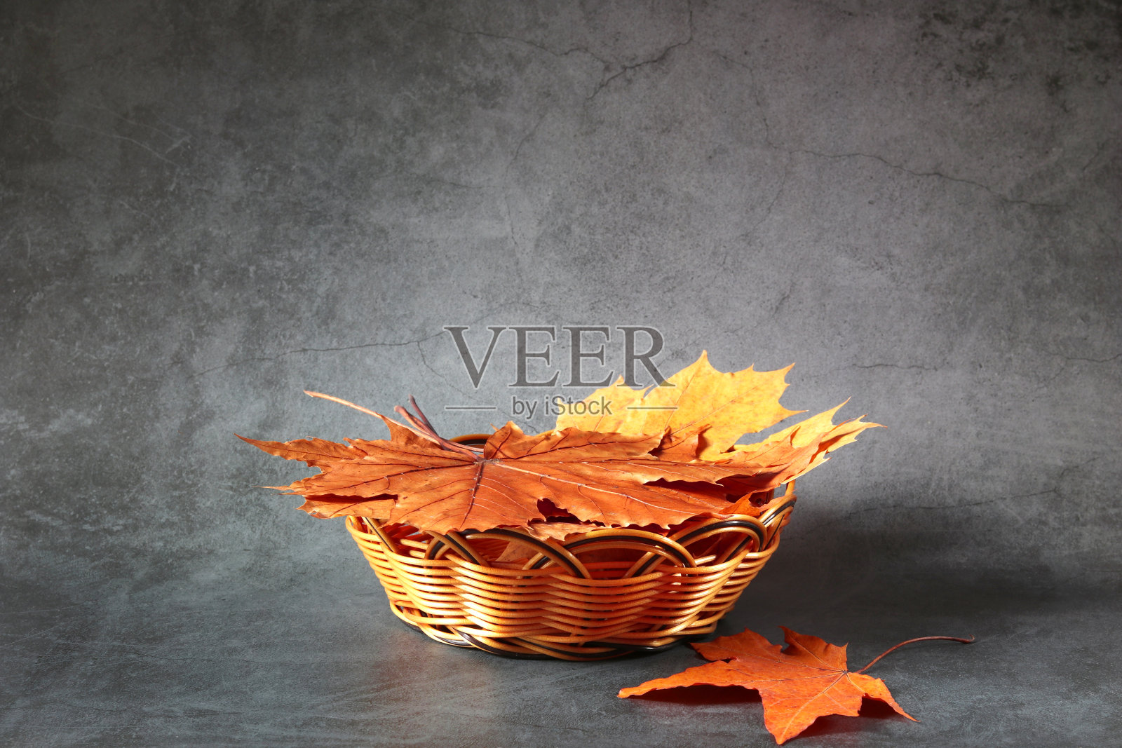 金色的柳条篮子里装满了秋天的枫叶在黑暗的背景。复制的空闲空间。概念的季节性和秋季博览会,展览,销售。照片摄影图片