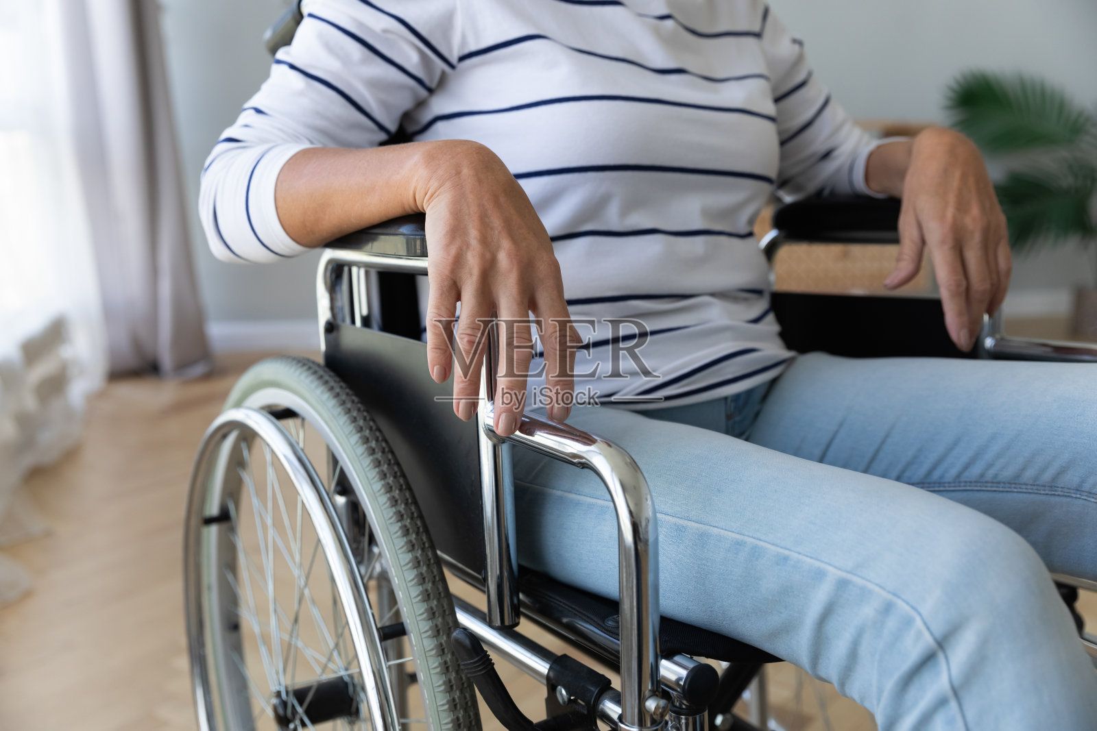 坐在医院或家中的轮椅上的残疾老妇人照片摄影图片