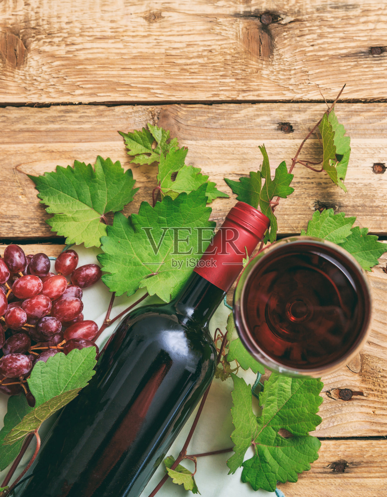 红酒杯和酒瓶,以及新鲜的葡萄木背景照片摄影图片