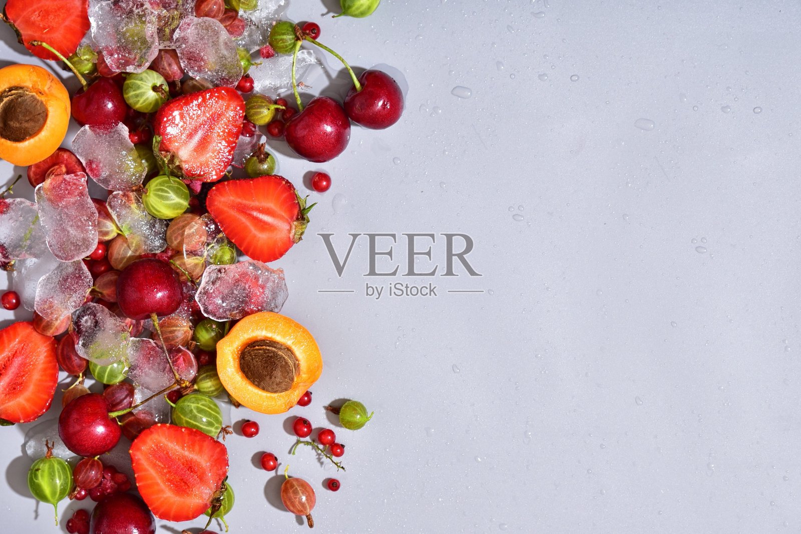 多色不同的水果在一个灰色的背景。文本。照片摄影图片