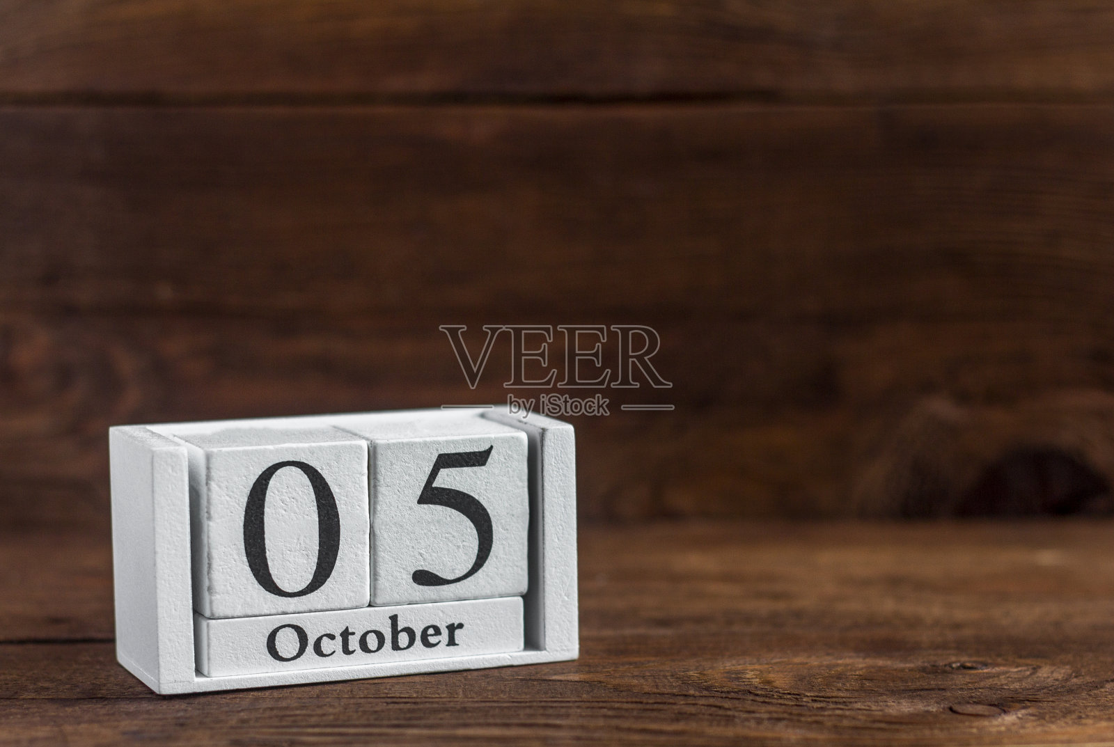在日历10月5日的深色木制背景上。秋季月份的日期。照片摄影图片