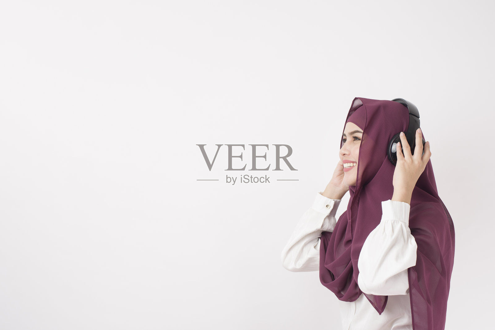 肖像美丽的妇女与头巾是享受听音乐的白色背景照片摄影图片