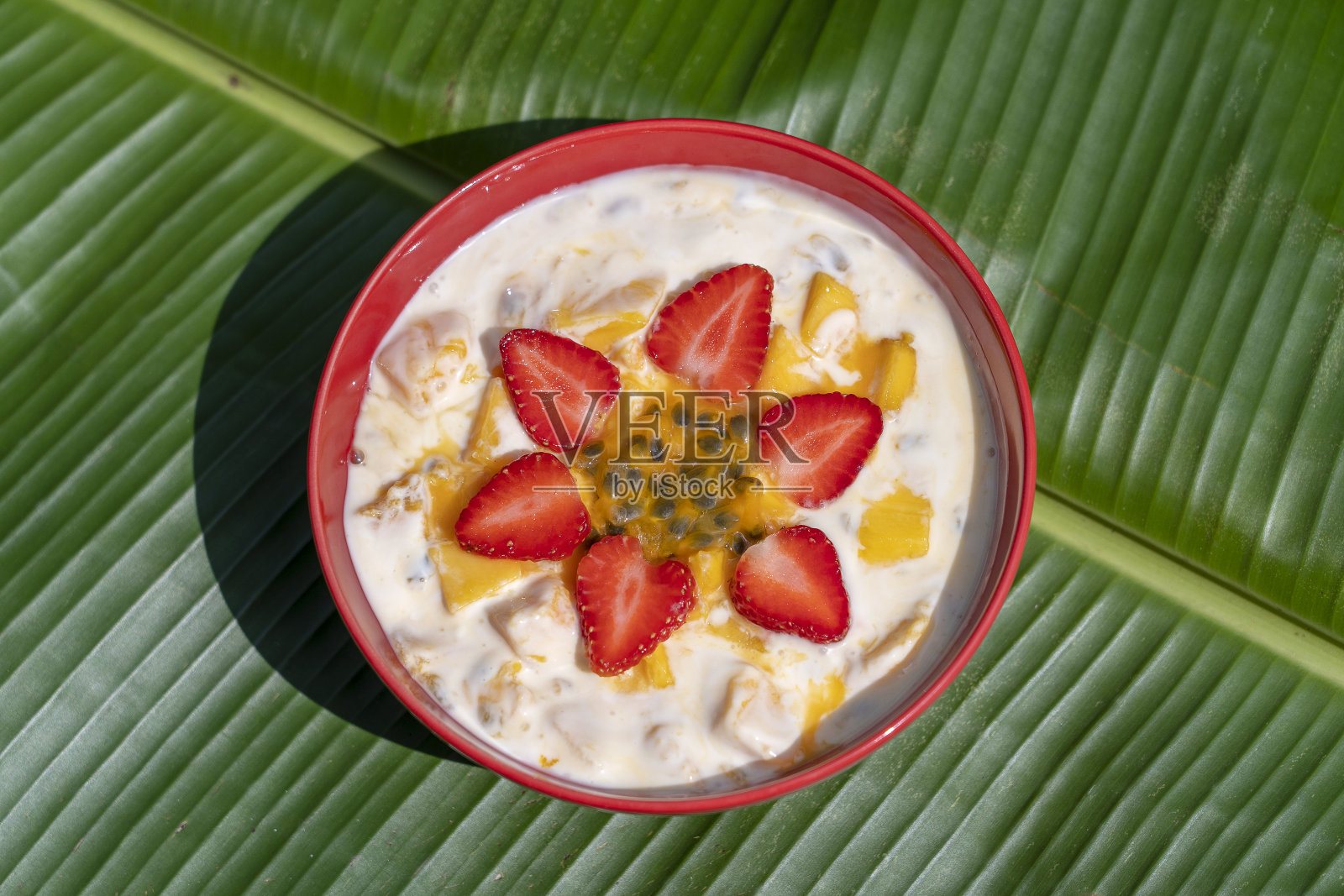 芒果,百香果,草莓和酸奶布丁。早餐水果甜点,搭配成熟的芒果和草莓,加上新鲜的百香果果肉照片摄影图片