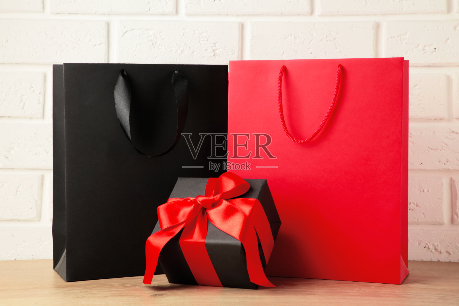 黑色和红色购物袋礼品在灯光背景。黑色星期五照片摄影图片