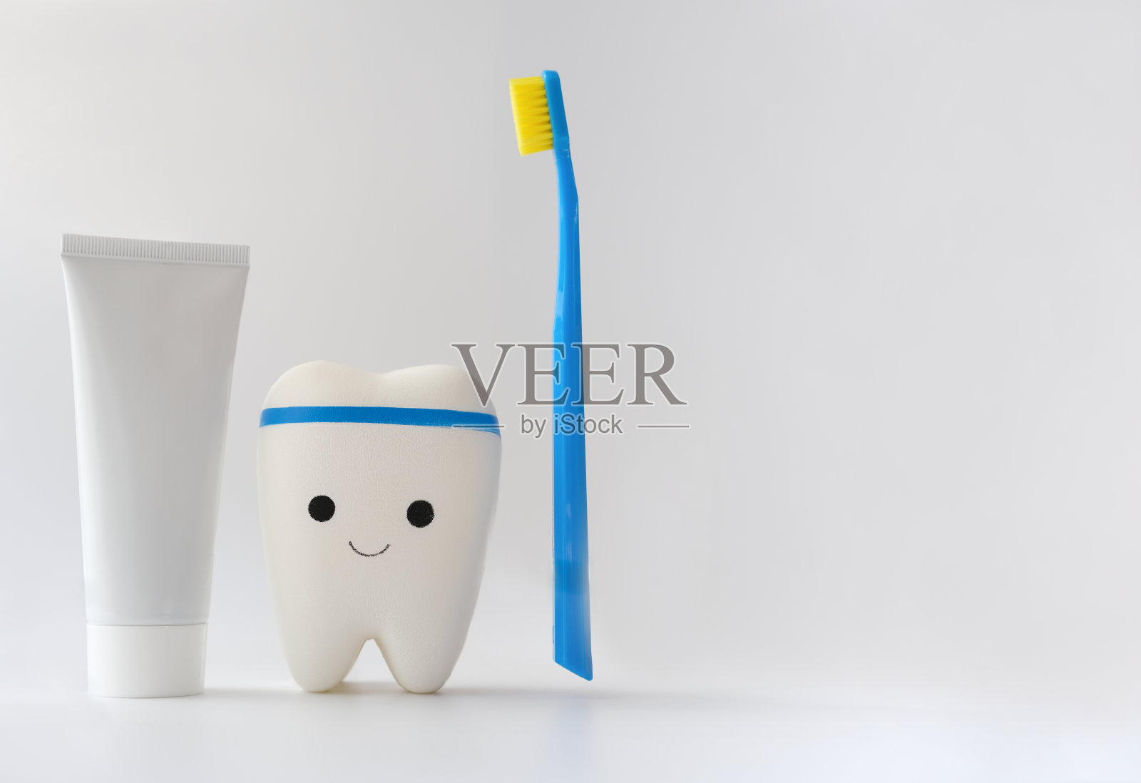白色背景上的玩具牙齿、牙刷和牙膏。口腔科、牙科诊所或牙科保健诊所之招牌。孩子口腔卫生。复制空间的广告或文字照片摄影图片
