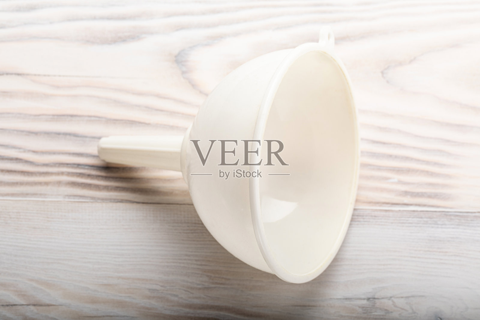 白色塑料漏斗液体在木制厨房桌子的背景上照片摄影图片