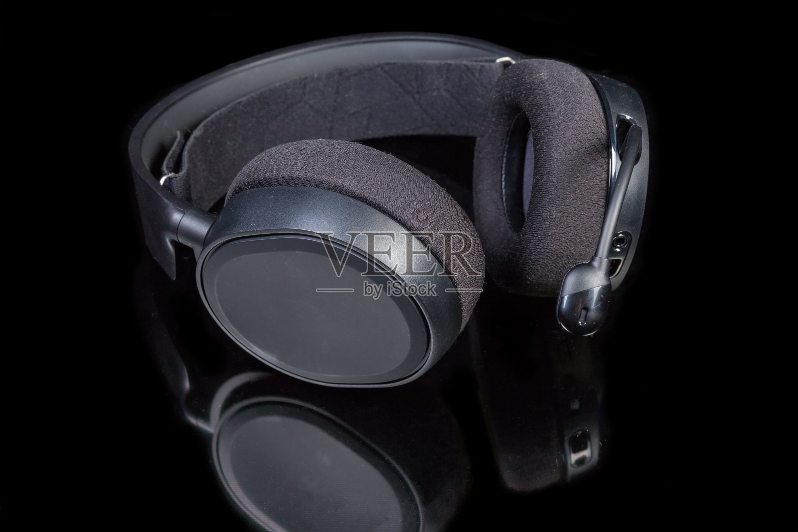 黑色耳机与全尺寸耳机在黑暗的表面照片摄影图片