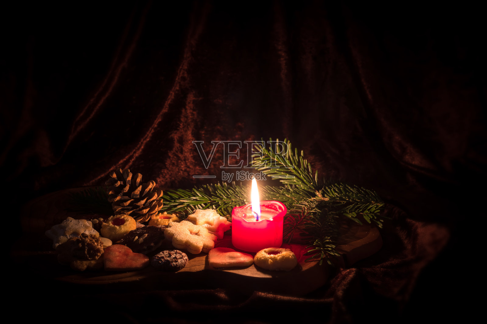 点燃的红烛站在装饰圣诞饼干之间的木板照片摄影图片