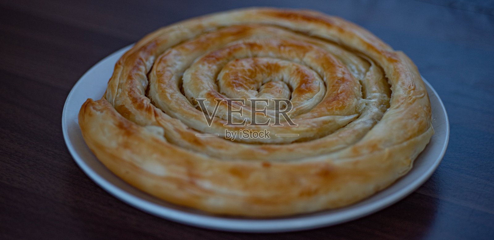 螺旋蜗牛形状的希腊奶酪派(Kichi Kozanis)宏观向上的看法。照片摄影图片