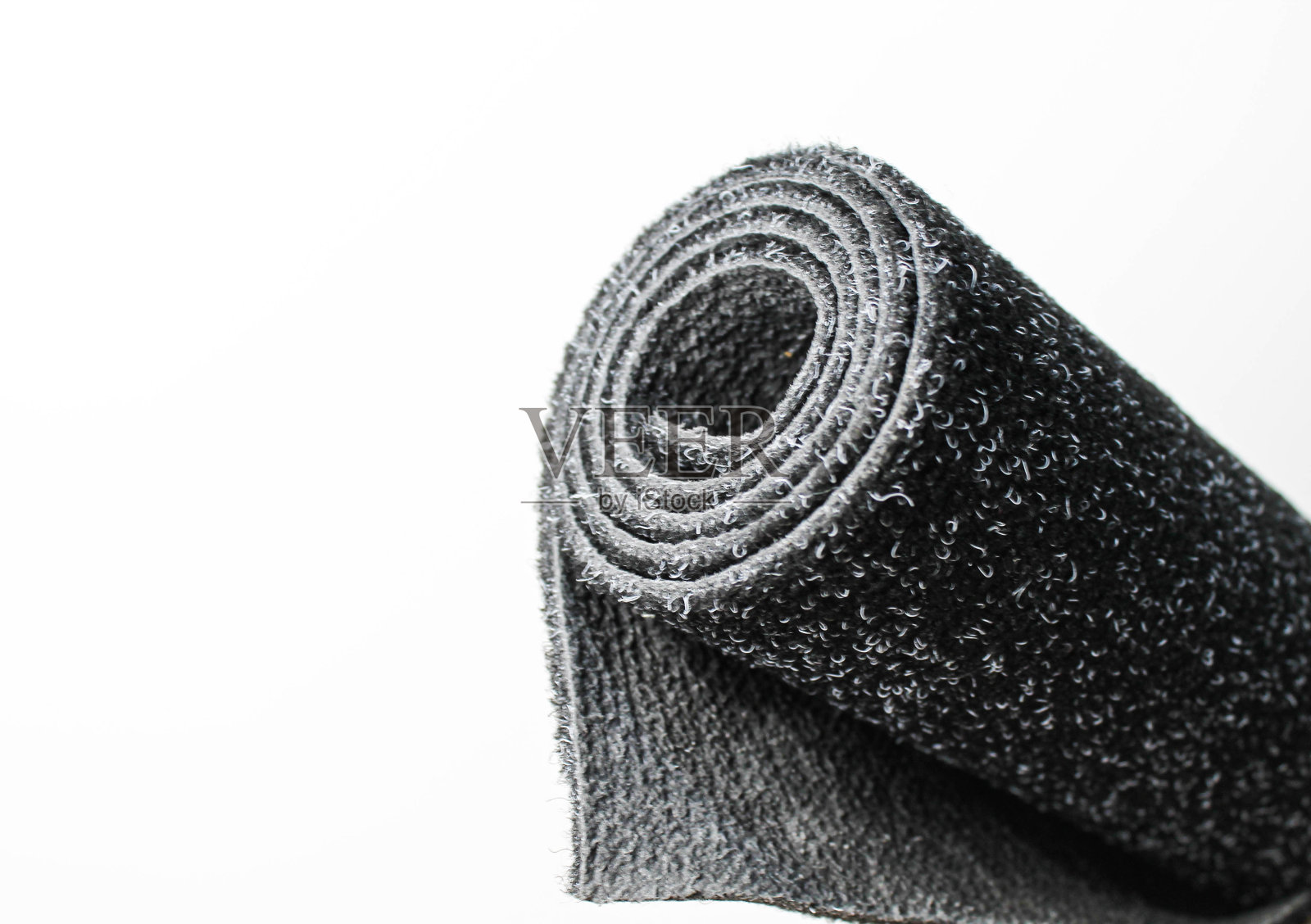 以白色背景为基础的橡胶地毯。从一卷地毯上剪下一块。照片摄影图片