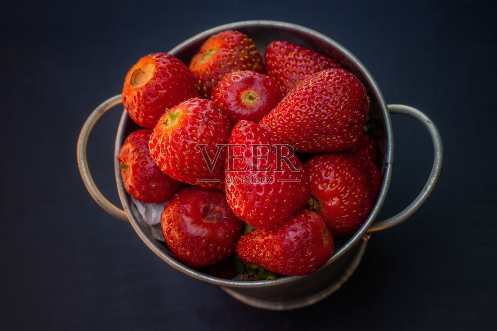 顶部装有新鲜草莓的金属桶照片摄影图片