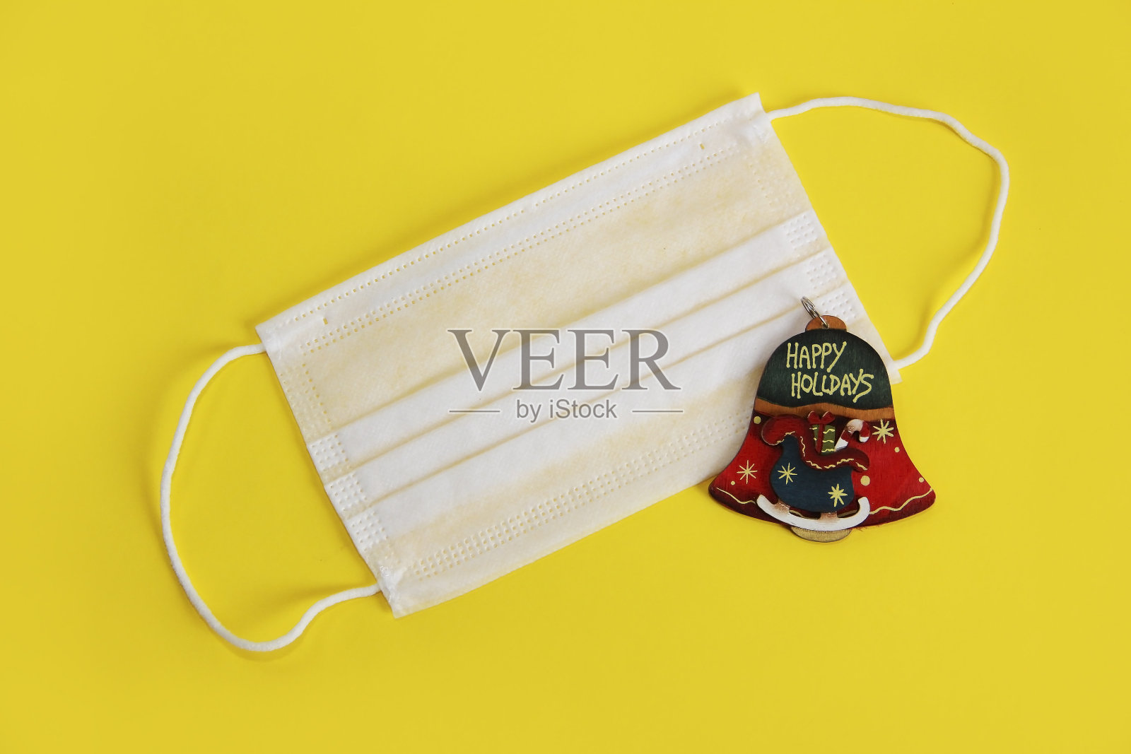 白色医用口罩和圣诞铃铛玩具照片摄影图片