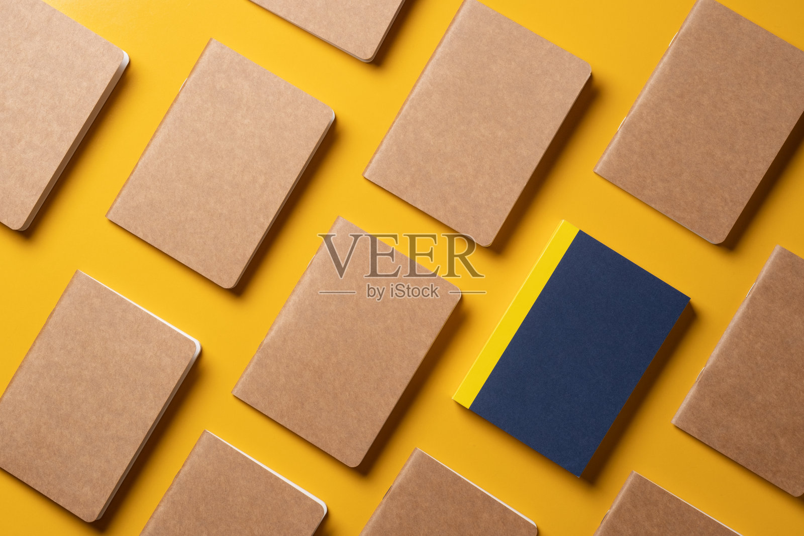 创意内容营销理念。顶部视图的蓝色笔记本对齐在模式上的黄色表背景。为在线广告内容的模型。独特的想法照片摄影图片