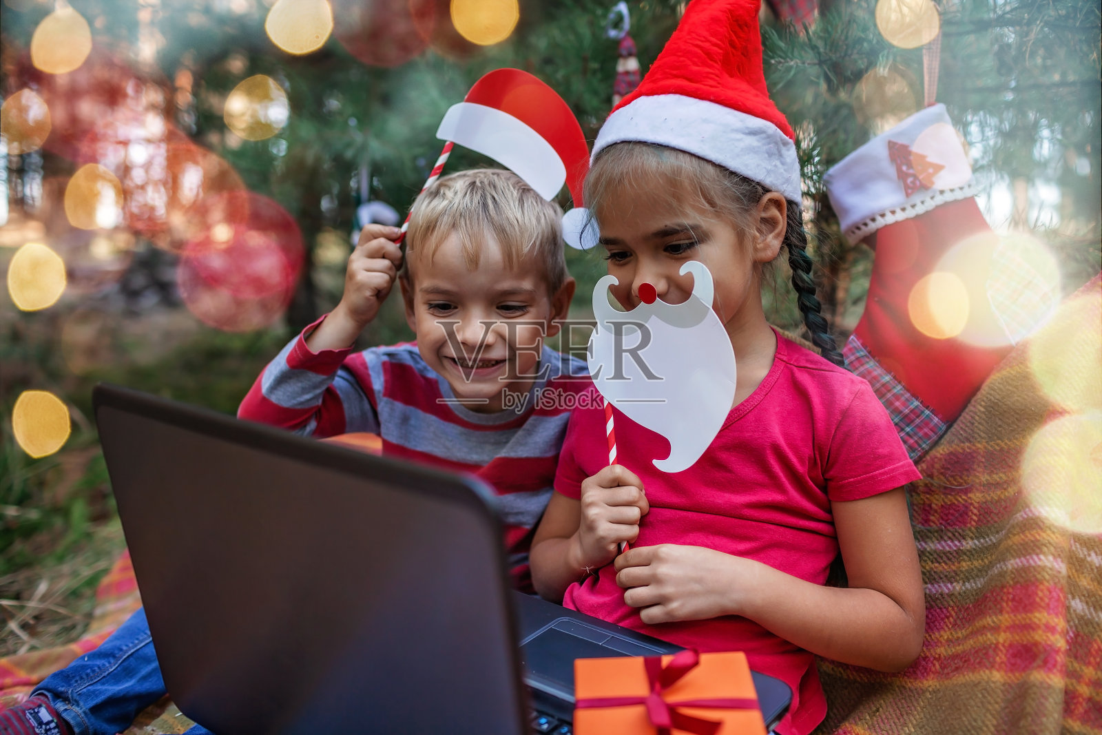 新常态的网上圣诞庆祝活动。孩子们通过视频聊天与家人庆祝照片摄影图片