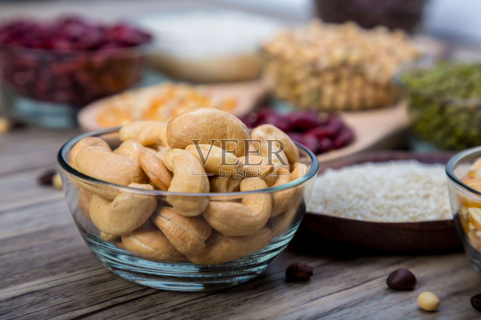 美味的腰果放在碗里的木桌上。一碗腰果放在木桌上。烤腰果照片摄影图片