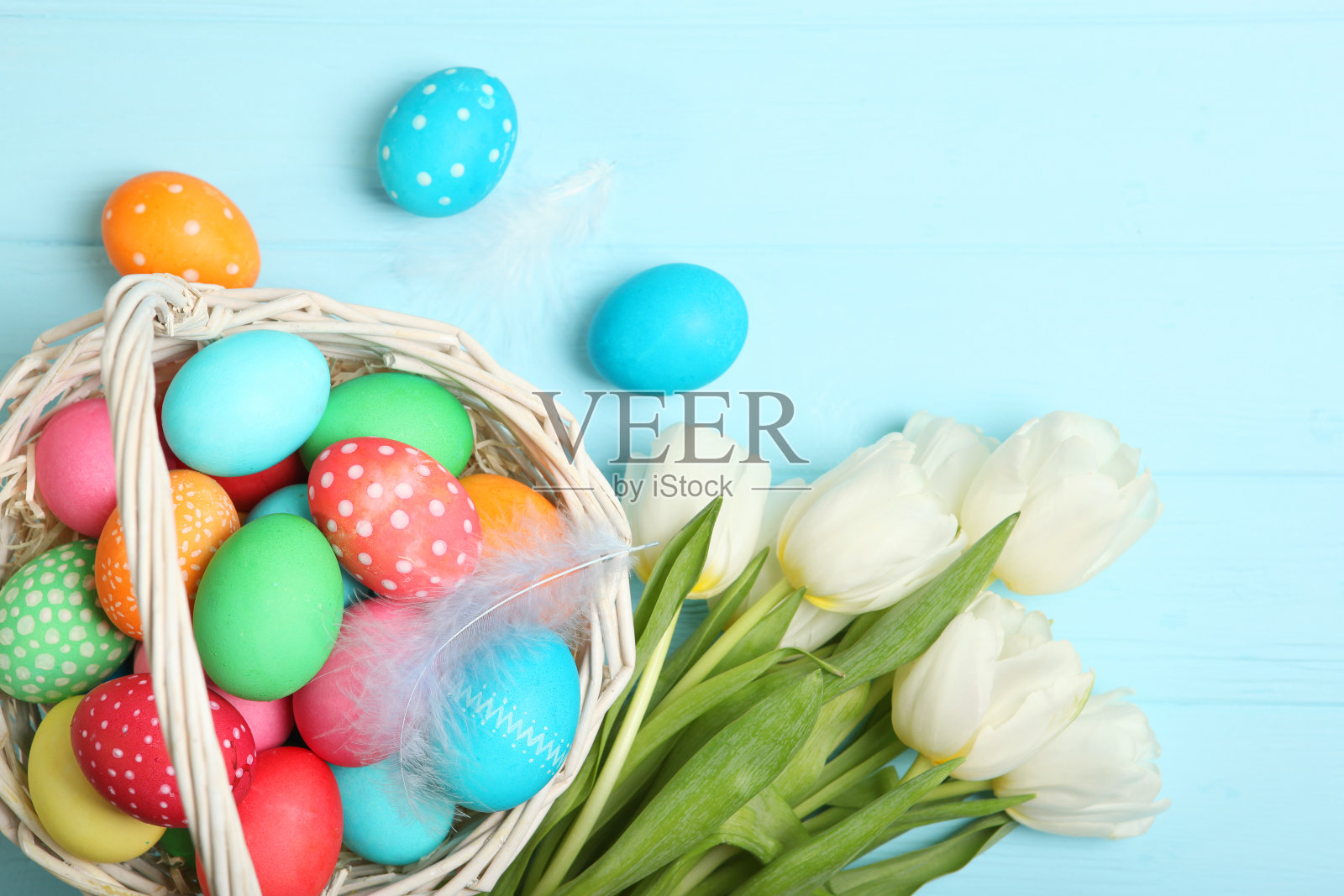 把复活节彩蛋和鲜花放在桌面上查看。复活节作文有插入文字的地方。照片摄影图片