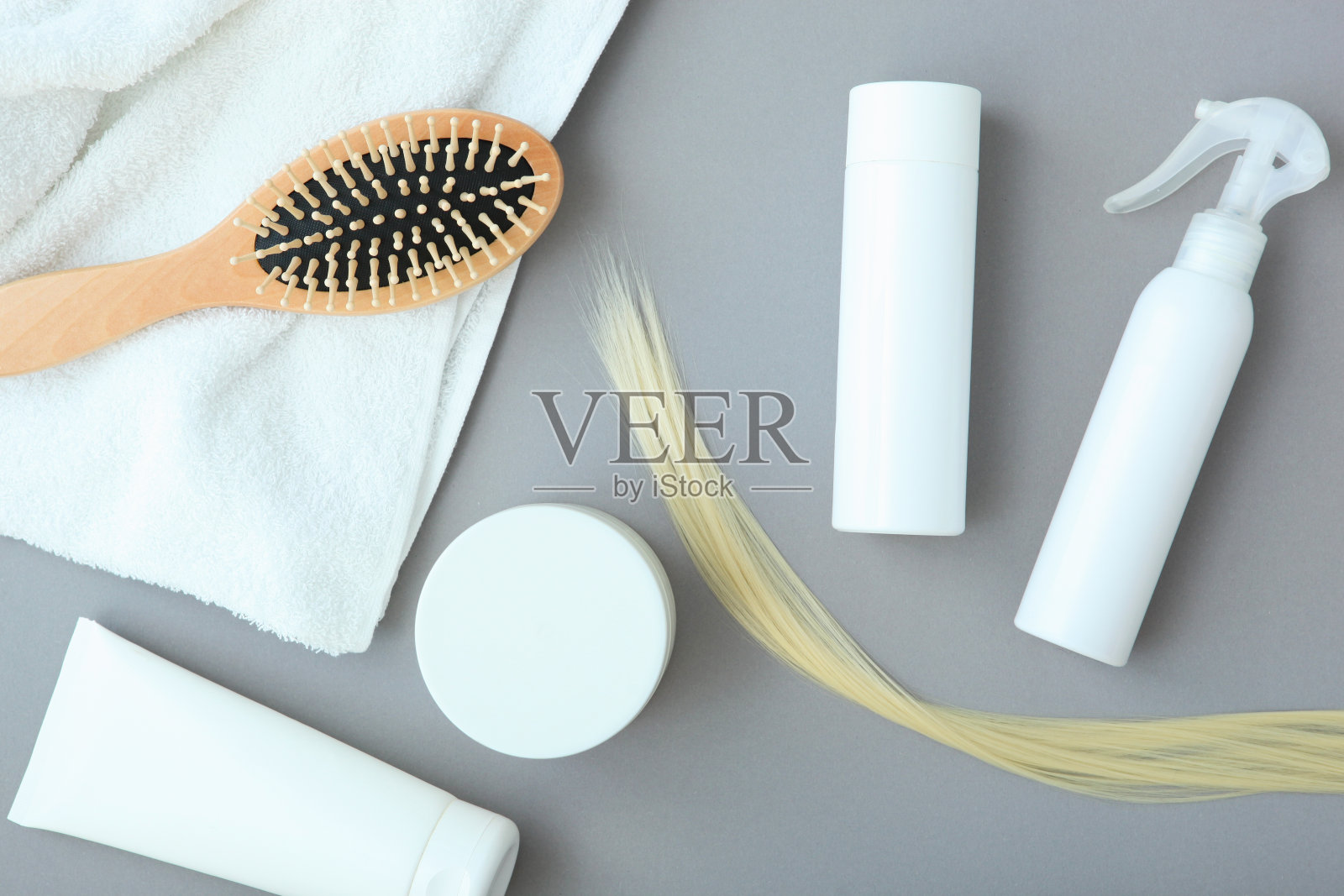 一缕金发,护发产品和梳子在彩色背景俯视图。照片摄影图片