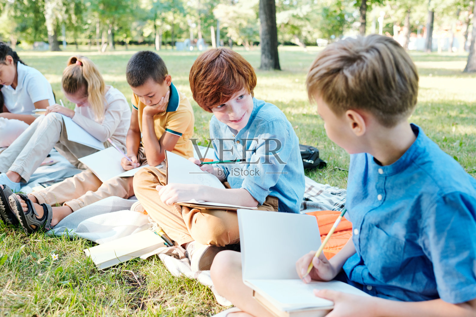 在户外课堂上给朋友展示测试答案照片摄影图片