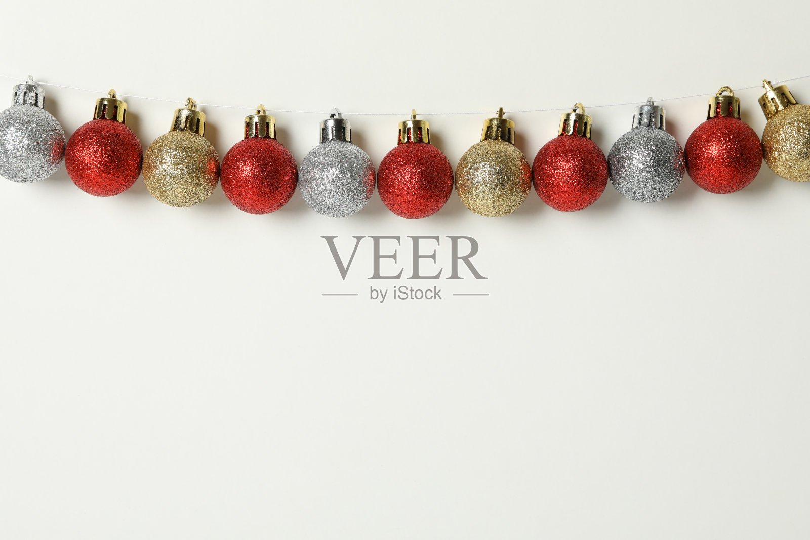 白色背景上用麻绳挂着的圣诞小装饰品照片摄影图片