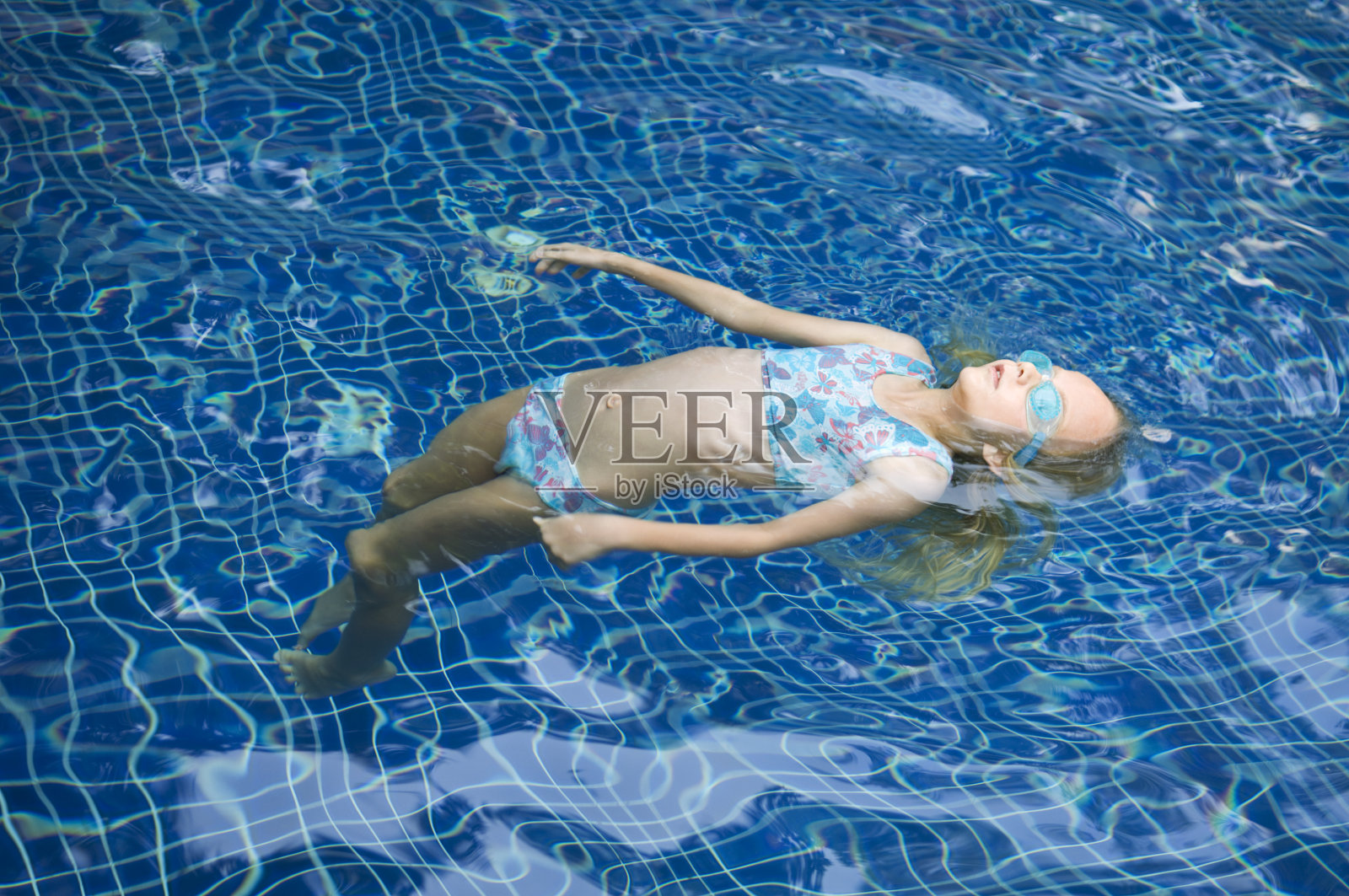 小女孩在游泳池里漂浮照片摄影图片