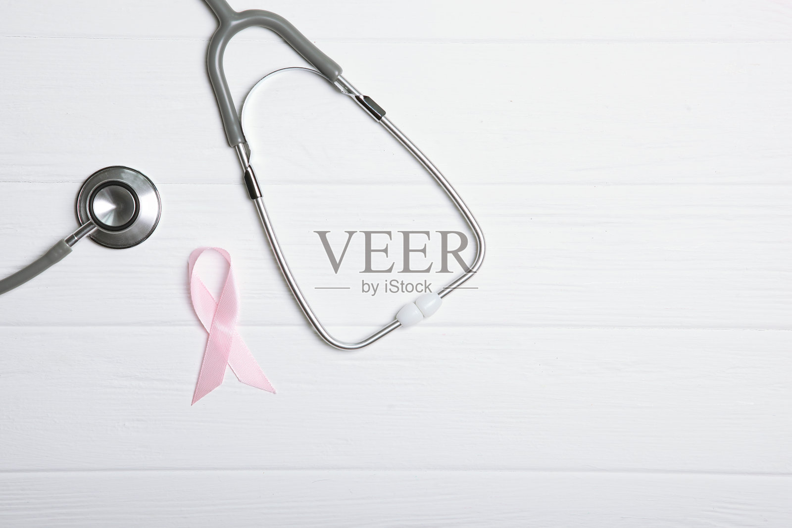 粉色丝带和听诊器在彩色背景俯视图。癌症的疾病。照片摄影图片