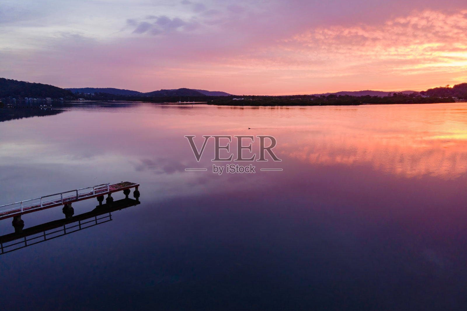 日出的倒影与柔软的高云在海滨照片摄影图片