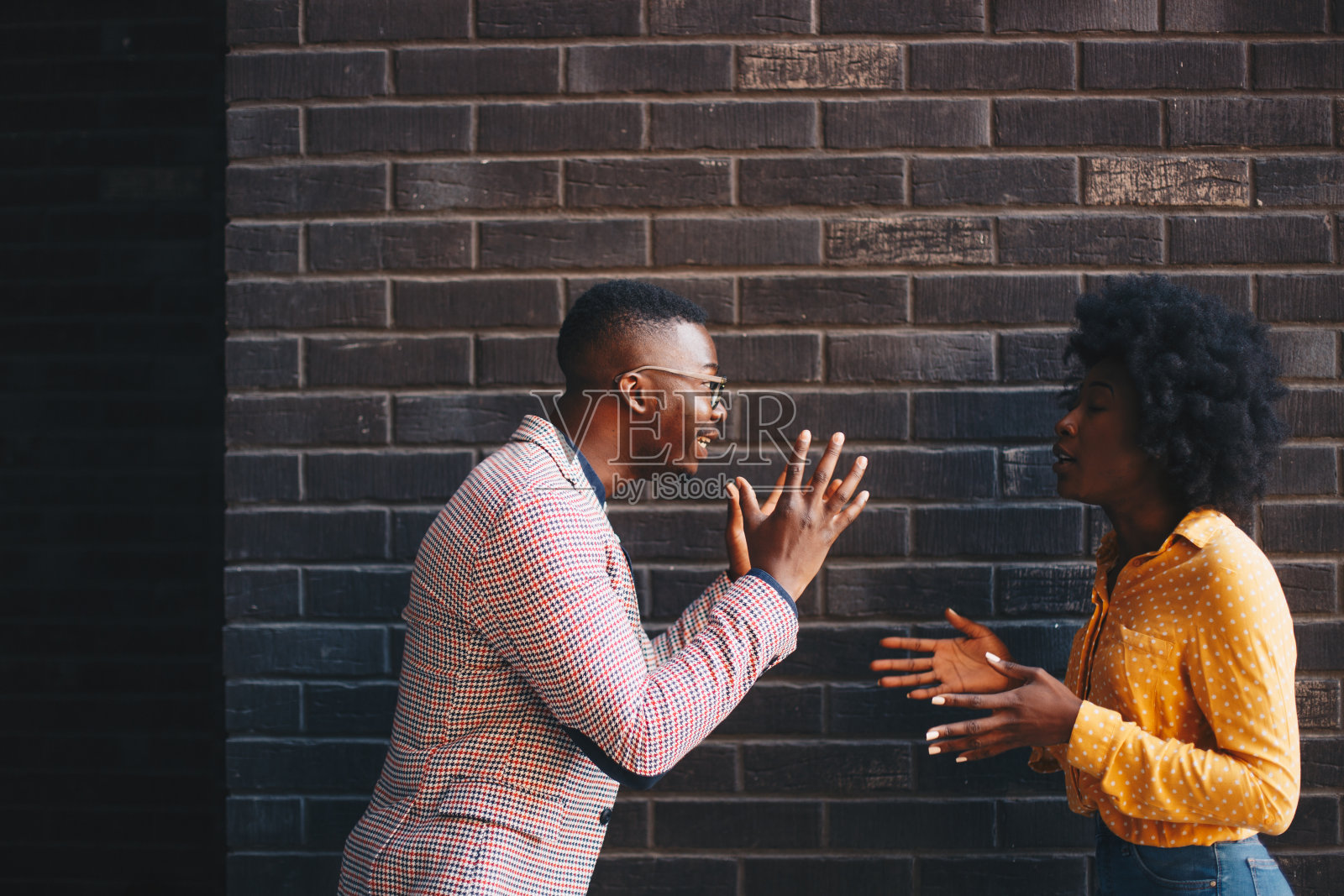 年轻女子与男子争论,男子倾听并反驳照片摄影图片