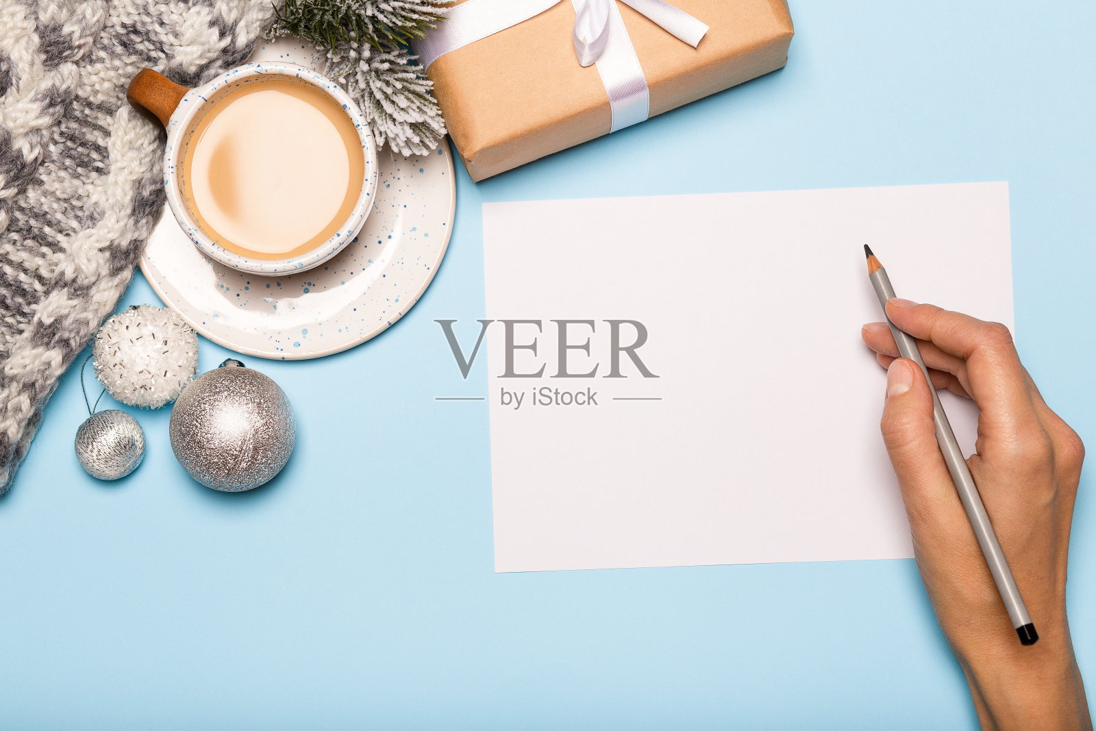 手写圣诞卡,纸盒和咖啡在蓝色的背景照片摄影图片