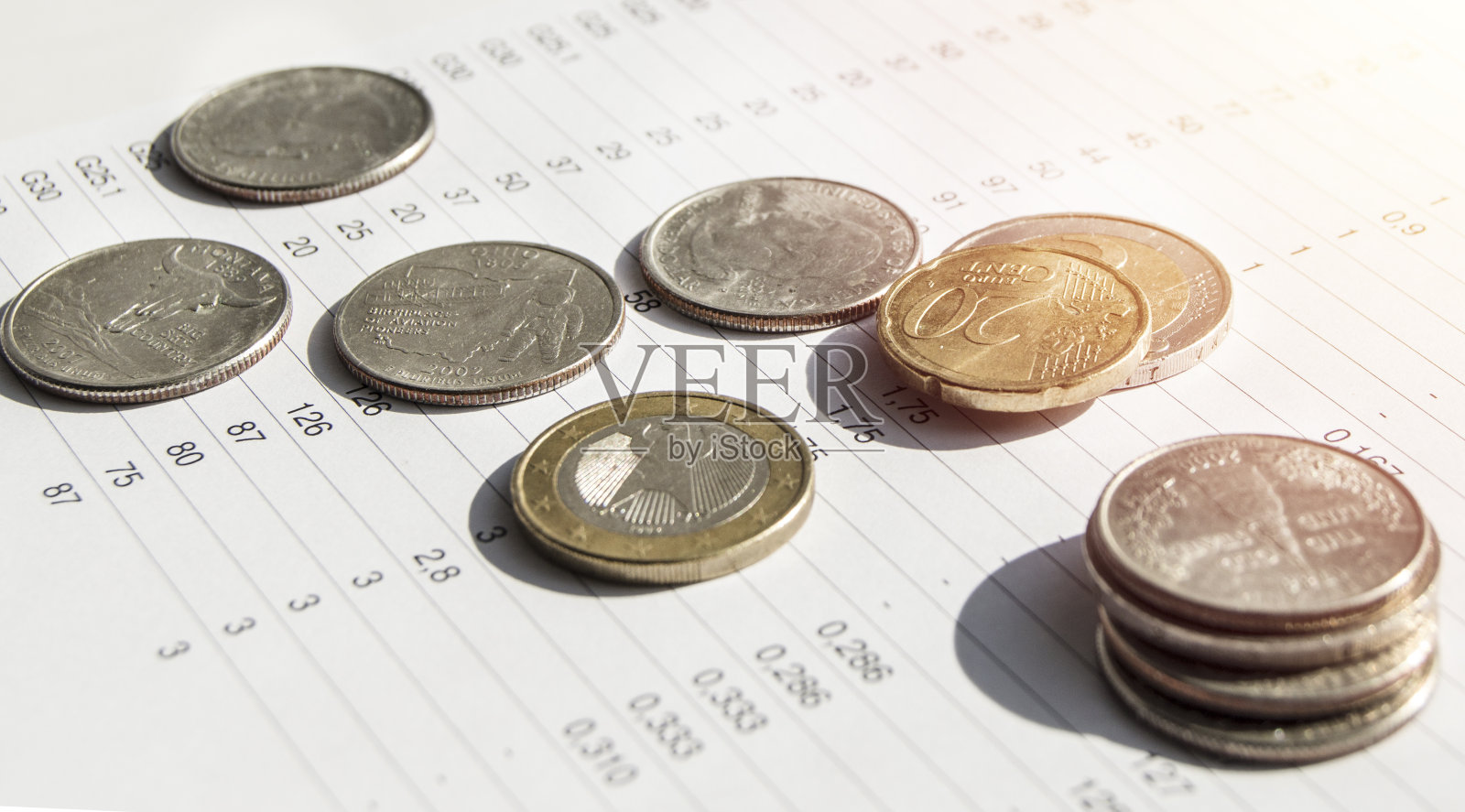 金属硬币躺在金融统计纸上,上面有一组数字特写灯和横幅照片摄影图片