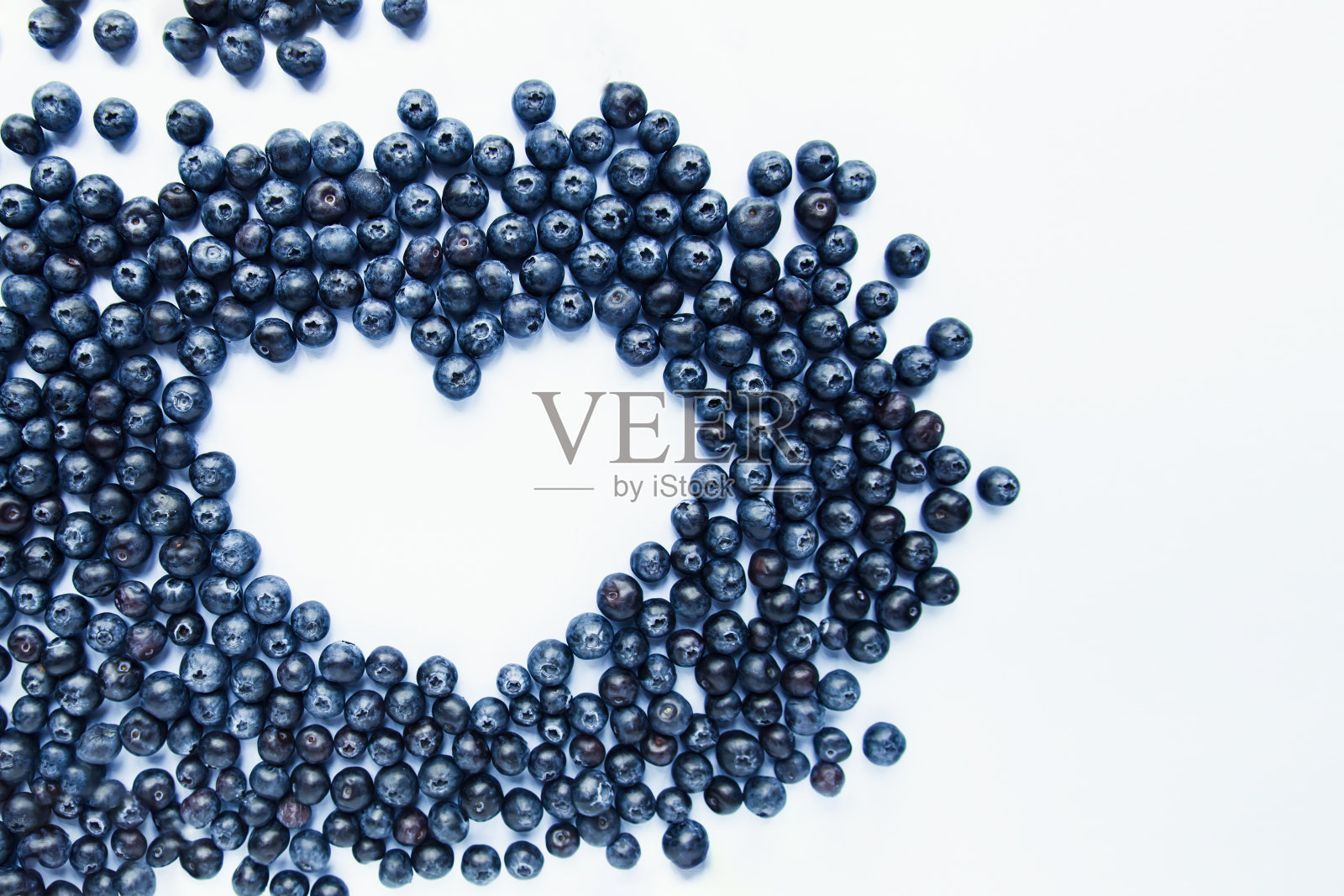 白色背景上的新鲜蓝莓做成的心形。健康食品,夏季浆果。最小的食品的概念。Flatlay。有选择性的重点。副本的空间。照片摄影图片