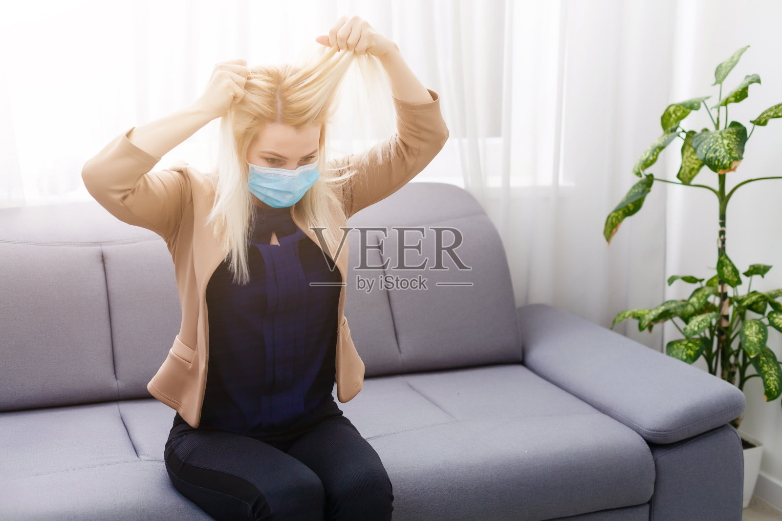 年轻的金发蒙面女人担心被隔离。冠状病毒、疾病、感染、隔离、外科绷带。照片摄影图片