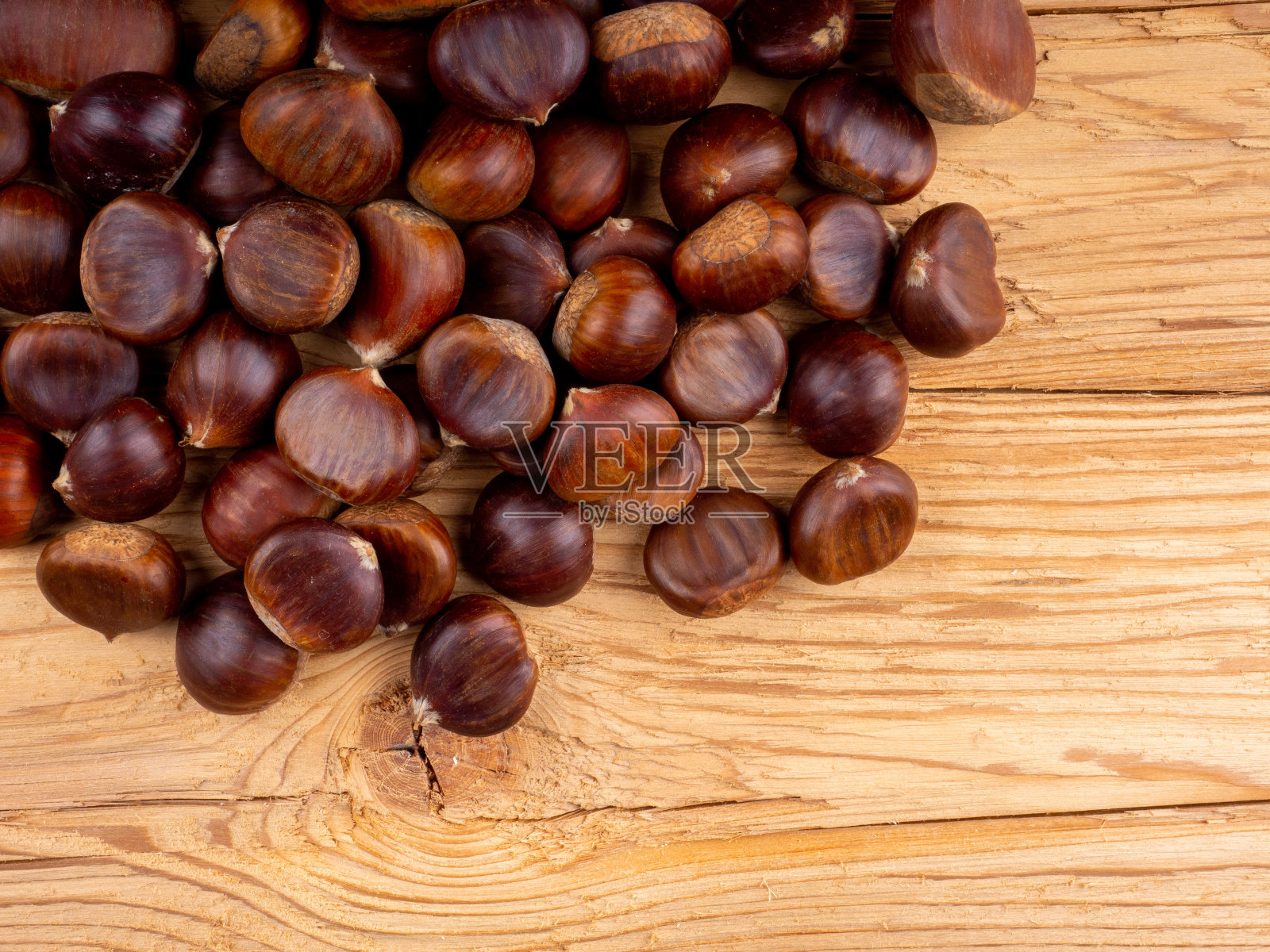 木质背景上的可食用栗子照片摄影图片